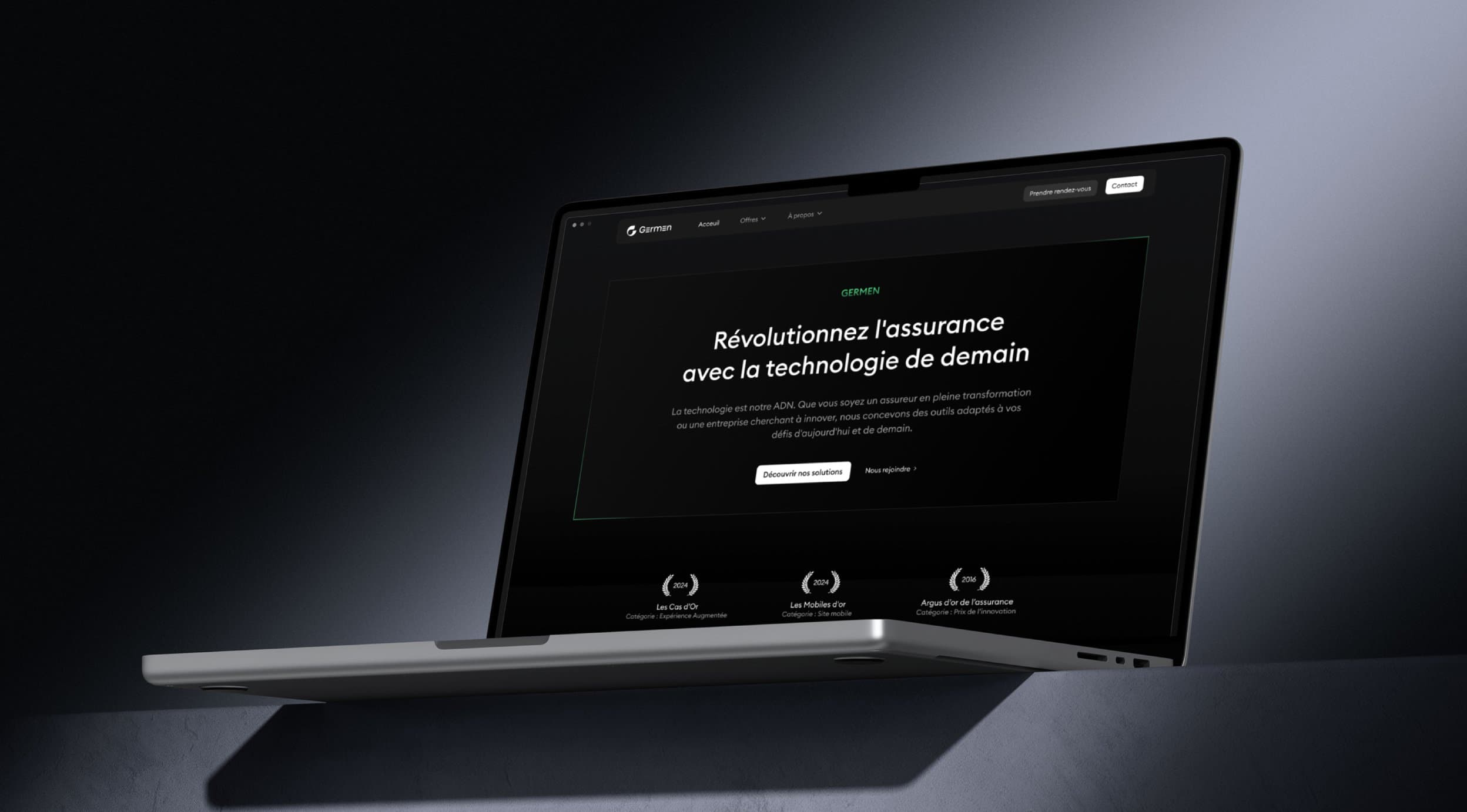 Un MacBook posé dans la pénombre affichant la page d'accueil du site Germen, titrée « Révolutionnez l'assurance avec la technologie de demain »