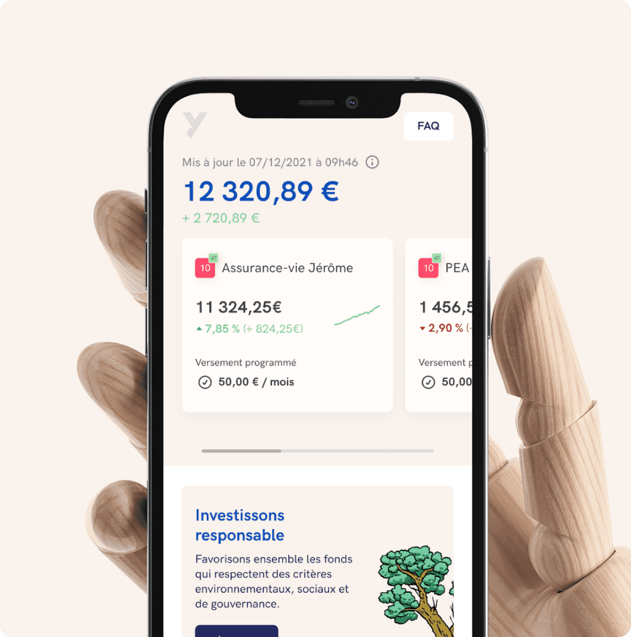 Une main en bois articulée tient un iPhone affichant le tableau de bord Yomoni : 12 320,89 euros d'épargne, les cartes assurance-vie et PEA, et le bloc « Investissons responsable »